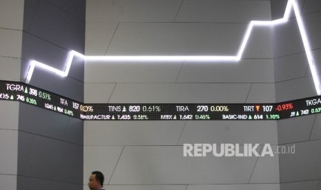  Karyawan melintasi layar Indeks harga saham gabungan (IHSG) di Bursa Efek Indonesia (BEI) Jakarta, Senin (7/8).