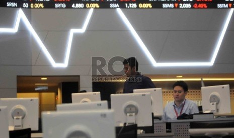 Karyawan memantau Indeks Harga Saham Gabungan (IHSG) pada layar papan indeks saham di Bursa Efek Indonesia (BEI), Jakarta, Kamis (9/7).