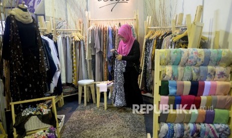 Karyawan menata produk fasion muslim yang di pamerakan pada The 2nd Indonesia Internasional Halal Lifestyle Expo & Conference (INHALEC) di Balai Kartini, Jakarta, Kamis (19/10).