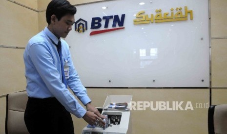 Karyawan menghitung uang di Banking Hall bank BTN Syariah, Jakarta, Senin (18/4).  (Republika/Agung Supriyanto)