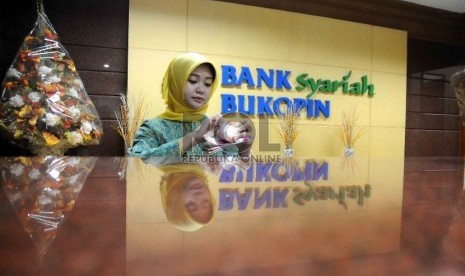 Karyawan menghitung uang di banking hall Bank Syariah Bukopin, Jakarta, beberapa waktu lalu. 