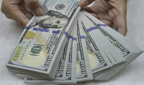 Karyawan menghitung uang dolar Amerika Serikat (AS) di tempat penukaran valuta asing, Jakarta, Rabu (6/1). Nilai tukar dolar AS jatuh untuk hari keempat berturut-turut terhadap sekeranjang mata uang utama lainnya pada akhir perdagangan Jumat (3/9), setelah laporan pekerjaan AS yang jauh lebih lemah dari perkiraan.