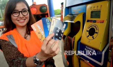 Karyawan menunjukan kartu e-toll usai Launching e-Payment Toll di Pintu Gerbang tol Jati Asih, Jakarta, Senin (21/3). (Republika/Prayogi)