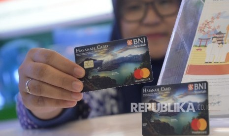 Karyawan menunjukkan Kartu BNI IB Hasanah Card spesial desain Lombok saat peluncuran, Jakarta, Jumat (22/9).