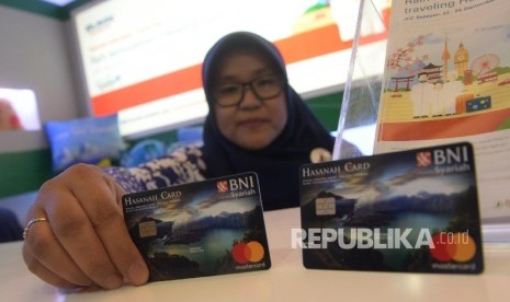 Karyawan menunjukkan Kartu BNI IB Hasanah Card spesial desain Lombok saat peluncuran, Jakarta, Jumat (22/9).