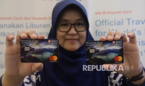 Karyawan menunjukkan Kartu BNI IB Hasanah Card spesial desain Lombok saat peluncuran, Jakarta, Jumat (22/9).