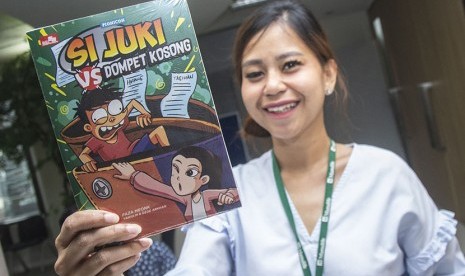 Karyawan menunjukkan komik Si Juki vs Dompet Kosong ketika peluncuran di Jakarta, Kamis (24/5). 