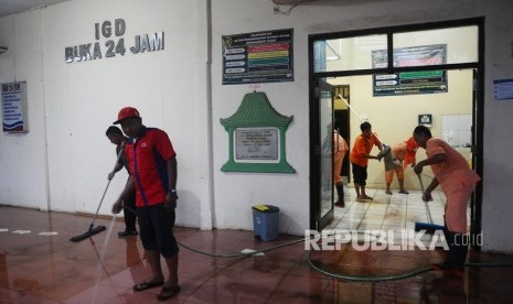 Karyawan rumah sakit membersihkan material sisa banjir di Mayong, Jepara, Jawa Tengah. Petambak bandeng di Jepara mengaku alami kerugian akibat banjir rob.