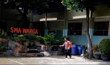 Karyawan SMA Warga Solo melakukan penyemprotan cairan disinfektan di halaman kelas setelah temuan kasus positif COVID-19 di sekolah setempat, Solo, Jawa Tengah, Kamis (27/1/2022). Setelah adanya 12 orang dari guru, siswa dan karyawan sekolah SMA Warga Solo yang terkonfirmasi positif COVID-19, pihak sekolah setempat mulai meniadakan Pembelajaran Tatap Muka (PTM) dengan mengganti sistem pembelajaran daring guna mencegah penyebaran Virus COVID-19.