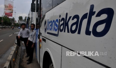  Karyawan Transjakarta berdiri disamping bus yang terparkir di kawasan Kebayoran Baru, Jakarta Selatan, Rabu (27/9). 