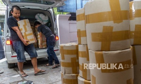 Karyawan yang bekerja di rumah yang diduga menjadi pabrik pembuataan pil jenis Paracetamol Caffein Carisoprodol (PCC) memindahkan barang bukti di bawah pengawasan petugas saat penggerebekan oleh Badan Narkotika Nasional (BNN), di Jalan Raya Halmahera, Semarang, Jawa Tengah, Ahad (3/12).