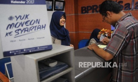 Karyawati melayani nasabah di Bank Pembiayaan Rakyat Syariah (BPRS) Al Salaam, Jakarta, Rabu (22/3).