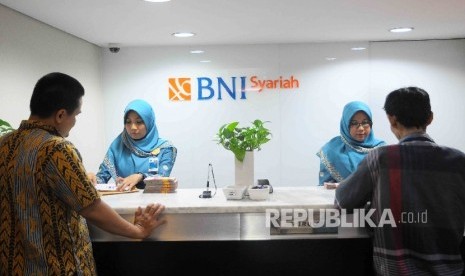  Karyawati melayani nasabah di Banking Hall Bank BNI Syariah, Jakarta, Rabu (18/1).