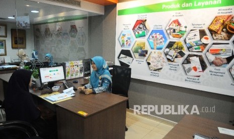  Karyawati melayani nasabah di banking hall Bank BNI Syariah, Jakarta, Jumat (10/2).