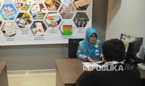 Karyawati melayani nasabah di Banking Hall Bank BNI Syariah, Jakarta, Selasa (1/11).