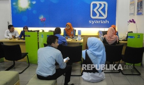  Karyawati melayani nasabah di Banking Hall Bank BRI Syariah, Jakarta, Rabu (17/5).