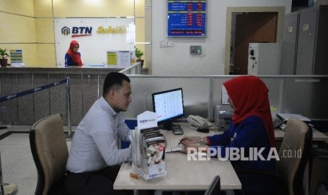 Karyawati melayani nasabah di Banking Hall Bank BTN, Jakarta.