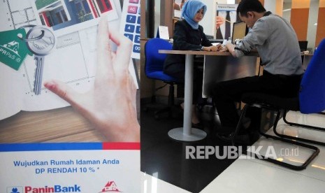 Karyawati melayani nasabah di banking Hall Bank Panin Syariah, Jakarta, Selasa (15/3).