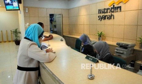  Karyawati melayani nasabah di Banking Hall Bank Syariah Mandiri, Jakarta, Selasa (20/9).