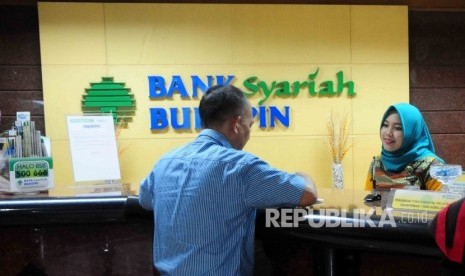  Karyawati melayani nasabah di Banking Hall Bank Syariah Bukopin, Jakarta.