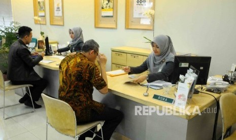 Karyawati melayani nasabah di banking Hall bank Syariah Mandiri (OBSM) di Jakarta, Jumat (20/1). 