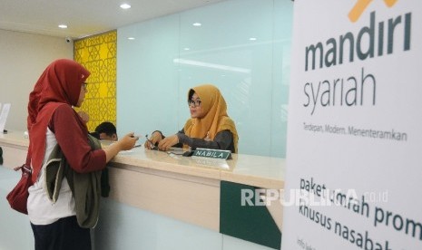 Karyawati melayani nasabah di Banking Hall Bank Syariah Mandiri, Jakarta, Senin (5/6).