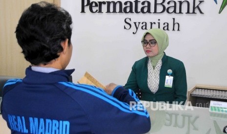  Karyawati melayani nasabah di Banking Hall Permata Bank Syariah, Jakarta, Selasa (10/1). 