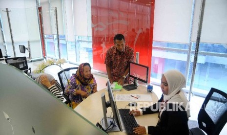 Karyawati melayani nasabah di Gedung Asuransi Prudential, Jakarta. 