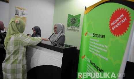 Karyawati melayani nasabah di koprasi simpan pinjam syariah baitul maal wa tamwil (BMT) Daarul Qur'an, Pal Batu, Jakarta, Senin (11/1). 