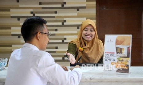 Karyawati melayani tamu yang hendak menginap di Hotel Sofyan, Jakarta, Rabu (18/12)