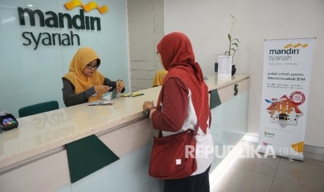 Karyawati melayanin nasabah untuk melakukan pelunasan Biaya Penyelenggaraan Ibadah Haji (BPIH) di Banking Hall Bank Syariah mandiri (BSM) Cabang Mayestik, Jakarta, Senin (10/4).