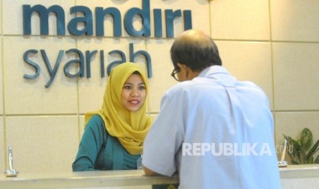 Karyawati mengenakan kebaya melayani nasabahnya di Banking Hall Bank Syariah Mandiri, Jakarta, Kamis (21/4).  (Republika/ Agung Supriyanto )