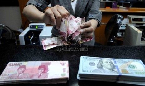 Karyawati menghitung mata uang rupiah di salah satu tempat penukaran valuta asing di Jakarta.