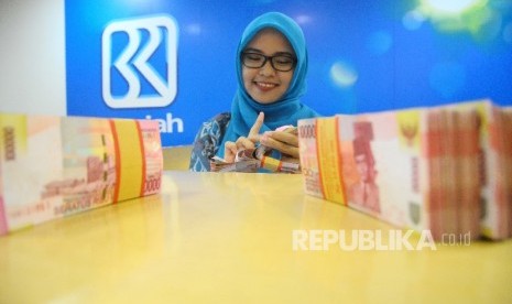 Karyawati menghitung uang di Banking Hall Bank BRI Syariah, Jakarta (ilustrasi). 