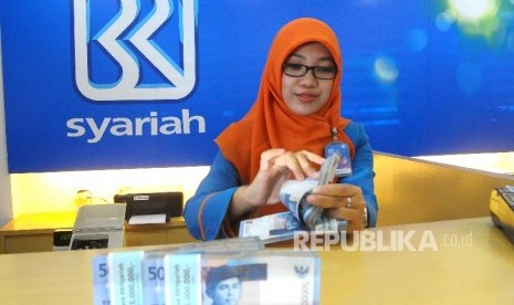 Karyawati menghitung uang di Banking Hall Bank BRI Syariah, Jakarta, Kamis (11/8). (Republika/Agung Supriyanto)