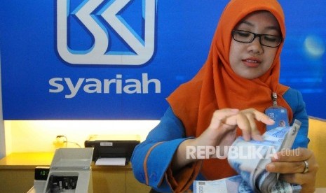 Karyawati menghitung uang di Banking Hall Bank BRI Syariah, Jakarta, Kamis (11/8). (Republika/Agung Supriyanto)