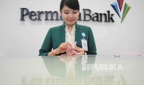 Karyawati menghitung uang di Banking Hall Bank Permata di Jakarta (ilustrasi). PermataBank dan Bangkok Bank Kantor Cabang Indonesia (BBI) resmi bersatu sesuai persetujuan Otoritas Jasa Keuangan (OJK) yang berlaku efektif sejak 21 Desember 2020.