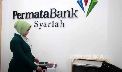 Karyawati menghitung uang di Banking Hall Bank Permata Syariah, Jakarta, Senin (9/5). (Republika/Agung Supriyanto)