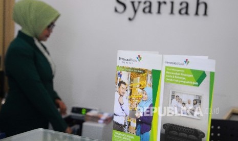 Karyawati menghitung uang di Banking hall Bank Permata Syariah, Jakarta, Selasa (14/3).