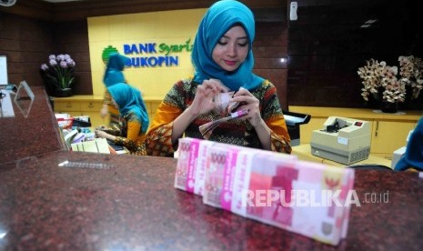 Karyawati menghitung uang di banking hall Bank Syariah Bukopin (BSB).  (Republika/ Agung Supriyanto)