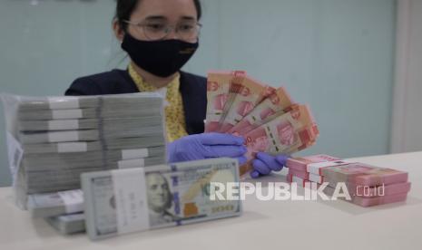 Karyawati menghitung uang rupiah dan dollar AS di salah satu bank di Jakarta, Kamis (10/9/2020). Berdasarkan data Bloomberg, nilai tukar rupiah pada perdagangan Kamis (10/9) ditutup melemah 56 poin atau 0,38% ke level Rp14.855 per dollar AS, dari perdagangan hari sebelumnya yaitu Rp14.799 per dollar AS. 