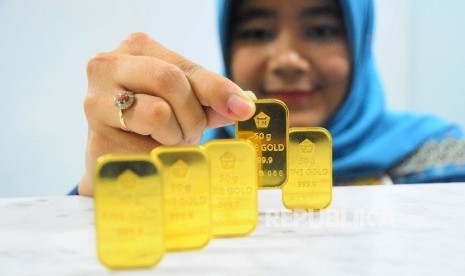  Karyawati menunjukan emas batangan. Direktur PT Solid Gold Berjangka Dikki Soetopo mengatakan pasar saham, termasuk perdagangan emas dunia mengalami lonjakan yang cukup tajam