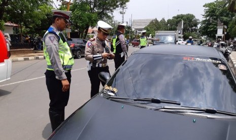 Kasat Lantas Polres Purwakarta AKP Ricky Adi Pratama, menindak salah seorang pengendara mobil yang melintasi perempatan Taman Pembaharuan, Selasa (30/10). 