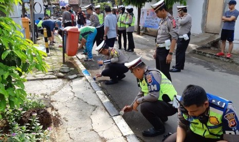 Kasat Lantas Polres Purwakarta AKP Ricky Adipratama, memimpin pengecatan trotoar Perum Oesman Singawinata, di Keluraham Nagri Kaler, Kecamatan/Kabupaten Purwakarta, Sabtu (1/12).  Perum ini, ditunjuk sebagai wilayah percontohan kampung tertib berlalulintas. 