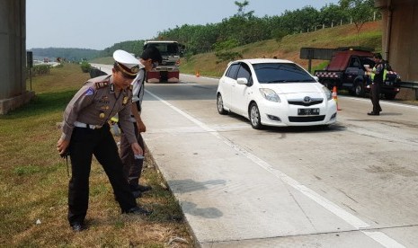 Petugas kepolisian melakukan evakuasi dan olah TKP pascakecelakaan di ruas Tol Cipali KM 76.400 jalur B, Kecamatan Campaka, Kabupaten Purwakarta, Jawa Barat, Sabtu (21/7). 