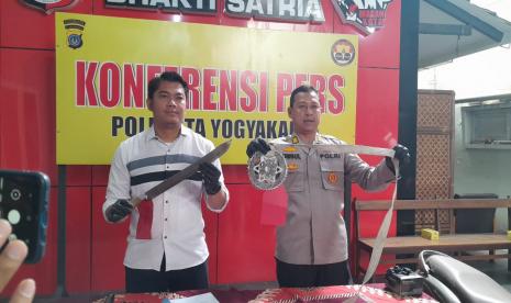  Kasat Reskrim Polresta Yogyakarta, AKP Archye Nevadha (kiri) dan Kabid Humas Polresta Yogyakarta, Timbul Sasana Raharjo (kanan) menunjukkan barang bukti sajam di Mapolresta Yogyakarta, Senin (30/1).