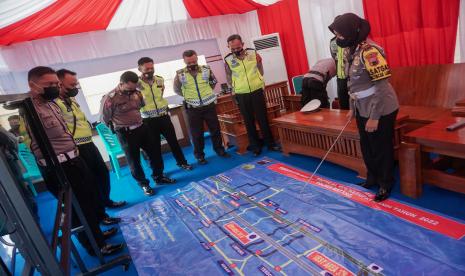 Kasatlantas Polres Batang AKP Dhayita Dhaneswari (kanan) melakukan koordinasi dengan anggota menggunakan tactical floor game di rest area tol KM 360 B, Kabupaten Batang, Jawa Tengah, Selasa (26/4/2022). Satlantas Polres Batang melakukan koordinasi untuk mengatur kelancaran lalu lintas di jalur Tol Trans Jawa di wilayah Kabupaten Batang saat diberlakukannya one way arus mudik dari Jakarta menuju Gerbang Tol Kalikangkung untuk memberikan kenyamanan dan kelancaran pemudik. 