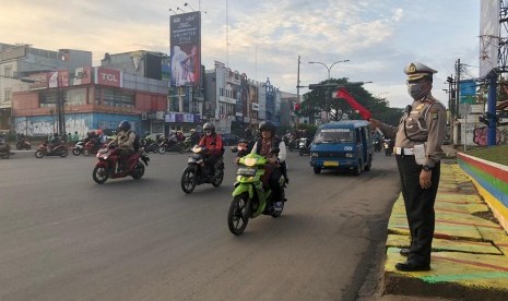 Kasatlantas Polrestro Depok, Kompol Sutomo sedang mengatur lalulintas di Jalan Margonda, Depok.