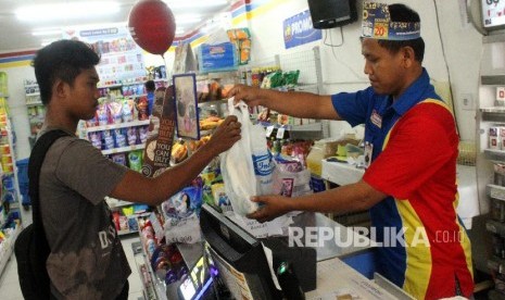 Kasir melayani konsumen berbelanja kebutuhan menggunakan kantong plastik di salah satu toko ritel, di Bekasi, Jawa Barat, Selasa (11/12). Pengusaha ritel meminta pemerintah memberikan insentif di tengah kelesuan penjualan akibat virus corona.