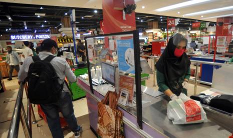 Kasir pasar swalayan membungkus belanjaan dengan kantong plastik di Padang, Sumatera Barat, Jumat (28/8). Lembaga kajian ekonomi Institute for Development of Economics and Finance (Indef) mengharapkan masyarakat membelanjakan bantuan sosial tunai yang diberikan pemerintah untuk konsumsi agar aktivitas ekonomi nasional meningkat. 